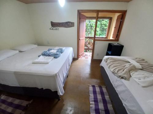 sypialnia z 2 łóżkami i oknem w obiekcie Capim Rosa Chá w mieście Mucugê
