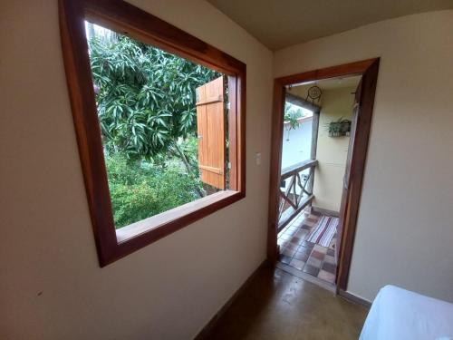 a room with a large window and a hallway at Capim Rosa Chá in Mucugê