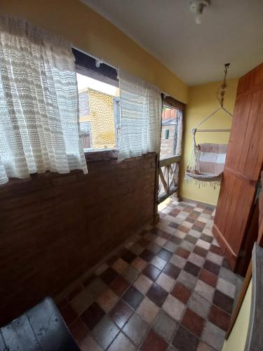 eine Küche mit einem karierten Boden und einem Fenster in der Unterkunft Capim Rosa Chá in Mucugê