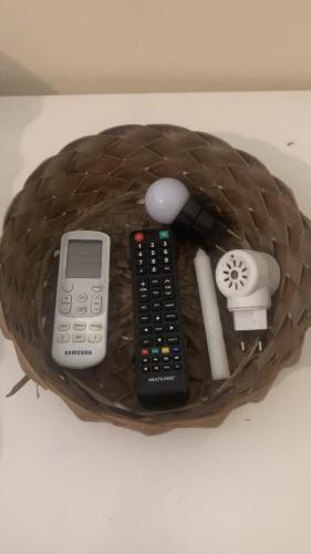 een afstandsbediening en andere elektronica in een mandje bij Portal Mágico in Itacaré