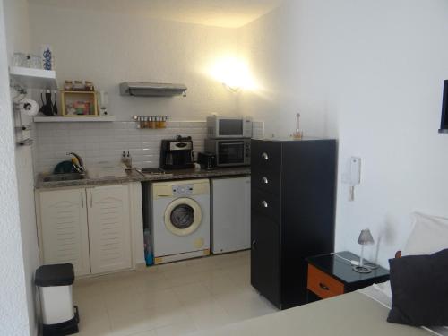 a kitchen with a refrigerator and a washing machine at STUDIO AU COEUR de CARTHAGE HANNIBAL in Carthage