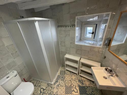 uma casa de banho com um WC, um lavatório e um espelho. em Tinoquero VTAR em Fuenteheridos