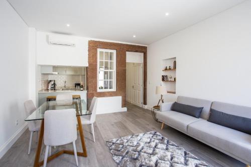 a living room with a couch and a table at Cayres Suites Surdo in Funchal