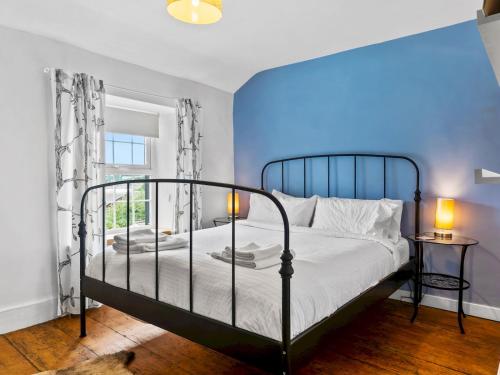 a bedroom with a bed and a blue wall at Pass the Keys Quaint Cottage Retreat in Charming Ulverston in Ulverston