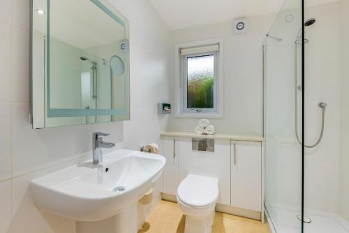 La salle de bains est pourvue d'un lavabo, de toilettes et d'une douche. dans l'établissement Pine Lake Resort, à Carnforth