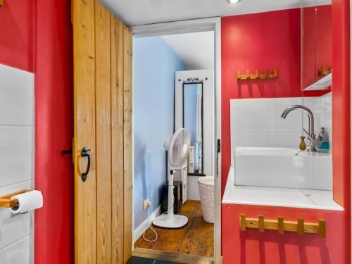 a bathroom with red walls and a sink and a toilet at Pass the Keys Quaint Cottage Retreat in Charming Ulverston in Ulverston