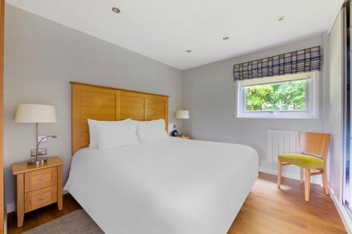 a bedroom with a large white bed and a chair at Pine Lake Resort in Carnforth
