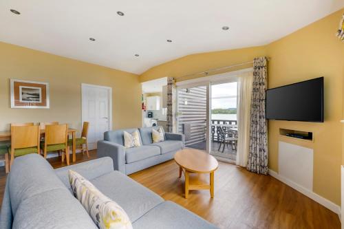 sala de estar con sofá y TV en Pine Lake Resort en Carnforth