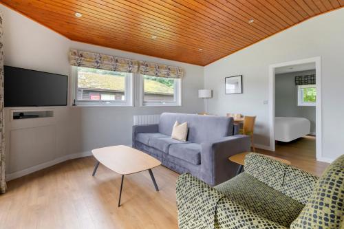 a living room with a couch and a tv at Pine Lake Resort in Carnforth