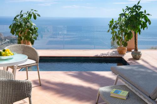 a patio with a table and chairs and a pool at San Domenico Palace, Taormina, A Four Seasons Hotel in Taormina