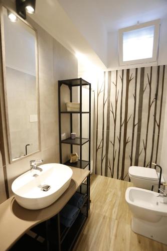 a bathroom with a sink and a toilet at Viscalori Homes in Viagrande