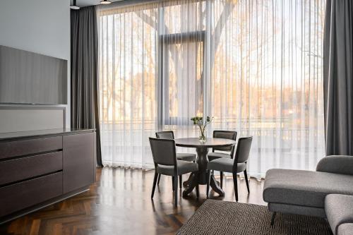 een woonkamer met een tafel en stoelen en een bank bij Roze Peldu Residence in Liepāja