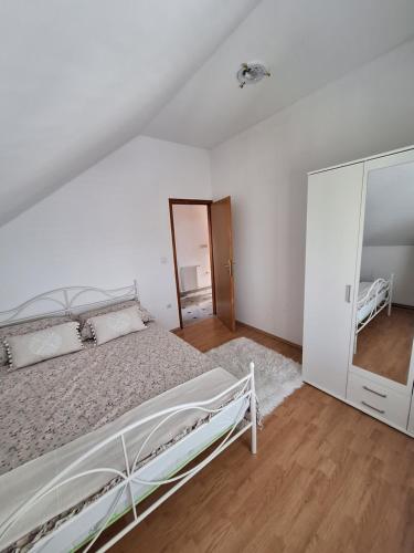 Habitación blanca con cama y espejo en Villa Zora, en Goli Breg