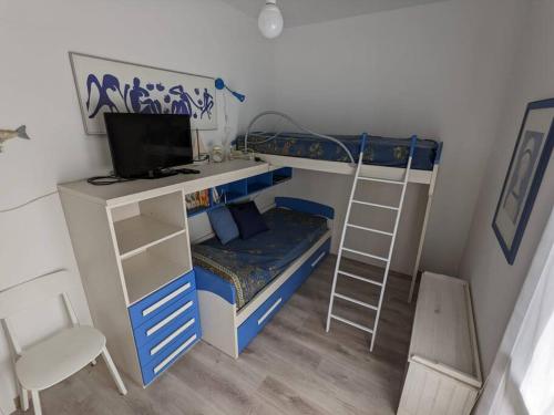Dormitorio con litera, escritorio y TV en Casa al mare Piera, en Cinquale