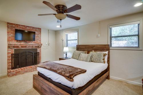 a bedroom with a bed with a fireplace and a ceiling fan at Louisiana Abode - Balcony, Pool Table and Lake Views in Lake Charles