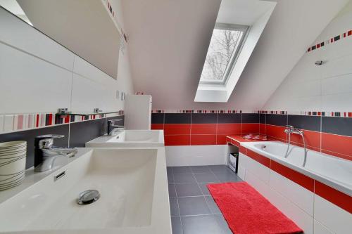 a bathroom with two sinks and a red rug at Holiday house Malšice in Malšice