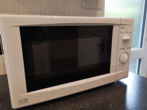 a microwave oven sitting on top of a counter at Abacus Bed and Breakfast, Blackwater, Hampshire in Camberley