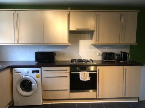 a kitchen with a stove and a washing machine at Greyfriar House in Brumby