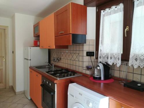 a kitchen with wooden cabinets and a stove top oven at Appartamento Poli con giardino in Castiglione dei Pepoli