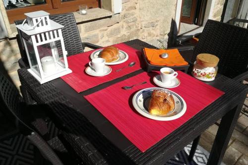 una mesa con dos platos de cruasanes y café. en Appartamento Poli con giardino, en Castiglione dei Pepoli