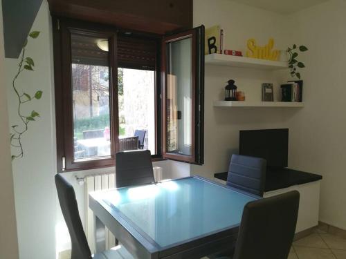 a dining room with a glass table and chairs at Appartamento Poli con giardino in Castiglione dei Pepoli