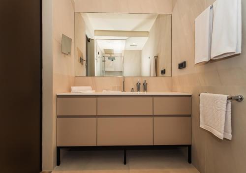 uma casa de banho com um lavatório e um espelho grande em Mirari Boutique Hotel em Split
