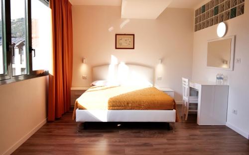a bedroom with a bed and a desk and a window at Victoria Royal Garden in Como