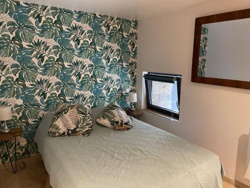 a bedroom with a bed with a green and white wallpaper at La Bergerie in Saint-Vincent