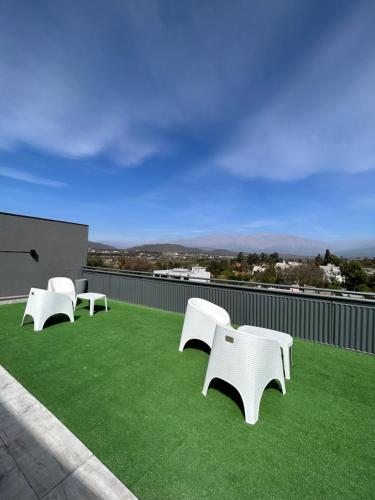 three white benches sitting on top of a roof at Terrazas del Fortín in San Salvador de Jujuy