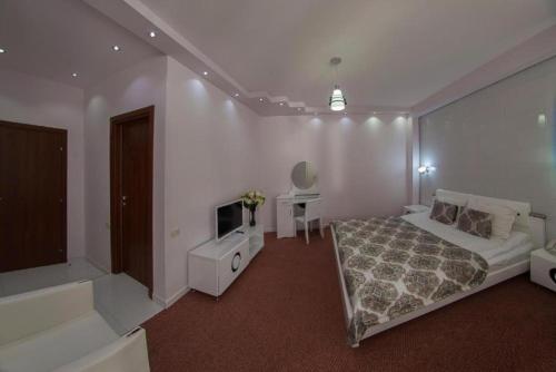 a bedroom with a bed and a tv in it at Alpina Resort by Stellar Hotels, Tsaghkadzor in Tsaghkadzor