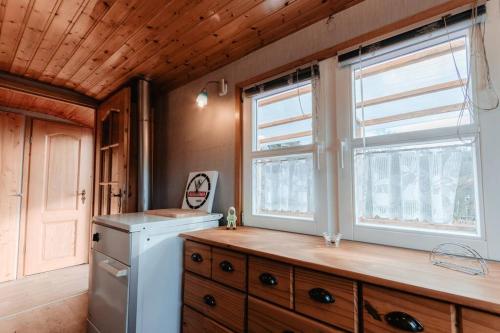 a kitchen with a washer and dryer and two windows at Tinyhouse auf dem Sonnenhang in Osterode