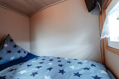 una camera da letto con un letto blu con stelle sopra di Tinyhouse auf dem Sonnenhang a Osterode