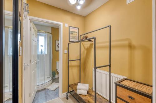 a bathroom with yellow walls and a stairwell at Malvern Hills Rosa Rambler Suite in Great Malvern