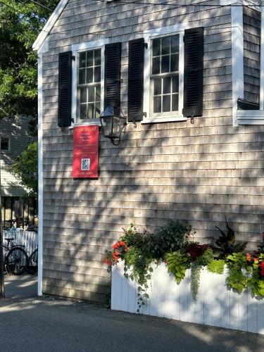 a house with two windows and flowers in front of it at Martin House 157 in Provincetown