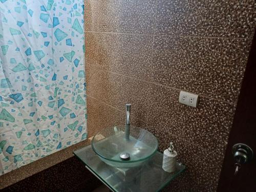 uma casa de banho com um lavatório de vidro numa mesa de vidro em DEPARTAMENTO EN YANAHUARA 3er piso em Arequipa