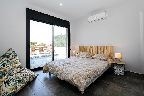 a bedroom with a bed and a large window at Villa Esperanza in Vidreres