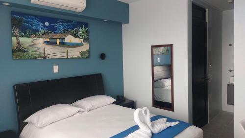 1 dormitorio con 1 cama con una pintura en la pared en Lucky`s Hotel & Casino, en San Isidro