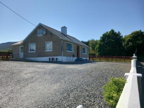 une maison sur une route en gravier avec une clôture dans l'établissement Havana Holiday Cottage Inishowen, à Cloghfin