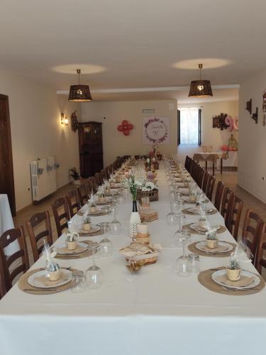 una mesa larga con platos y copas de vino. en Supramurgia Agribistrot, en Cassano delle Murge