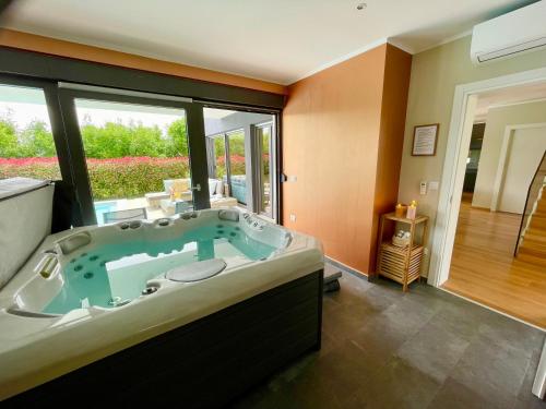 a large bathroom with a large tub with a large window at Luxury Villa Hedone with heated pool, welness and playground in Rakalj