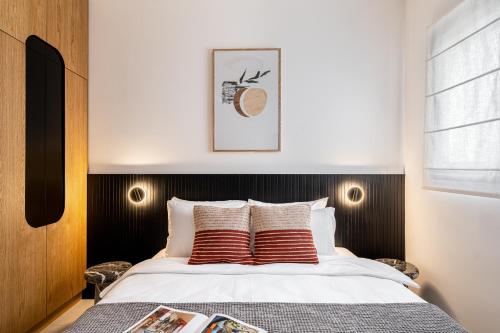 a bedroom with a bed with red and white pillows at Mate GEORGE - By HOMY in Tel Aviv