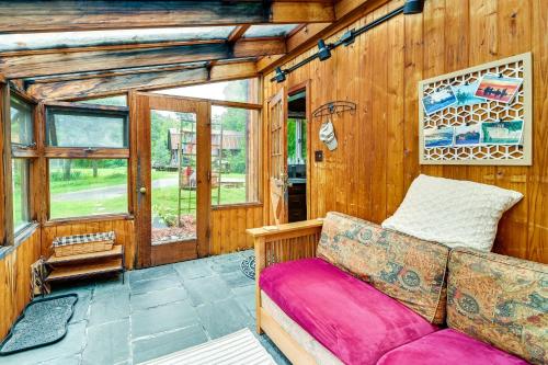 a couch sitting in a room with wooden walls at Canandaigua Getaway with Deck and Sunroom! in Canandaigua