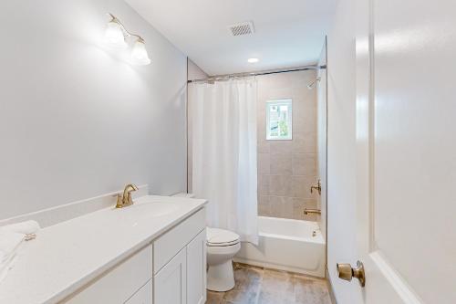 a white bathroom with a toilet and a shower at Town of Rehoboth Beach - 99 Sussex St Unit #4 in Rehoboth Beach