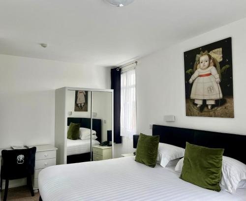 a bedroom with two beds and a mirror at Sarum Apart-Hotel in Saint Helier Jersey