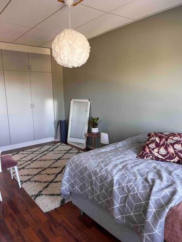 a bedroom with a bed and a chandelier at A stylish, newly decorated home! in Raahe