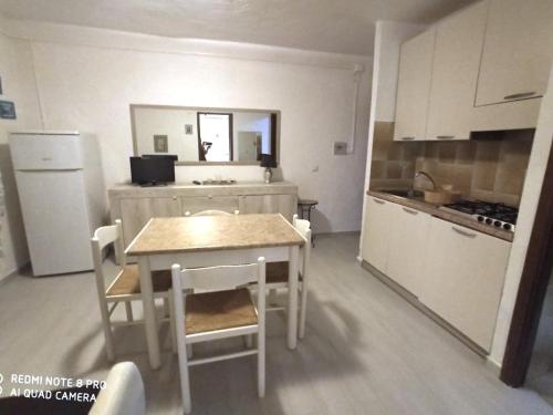 a kitchen with a table and chairs and a kitchen with a refrigerator at Baia de Bahas - Apartments & Resort in Santa Marinella