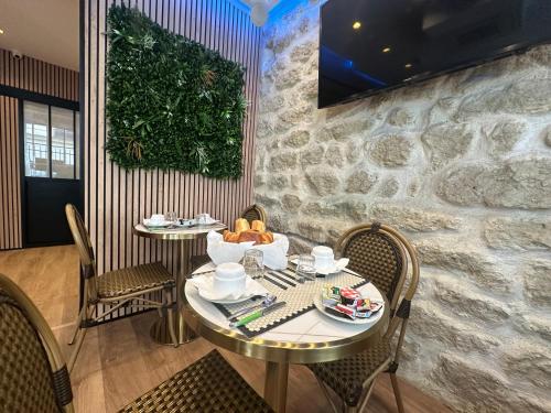 a dining room with two tables and chairs at Hotel Nation Montmartre in Paris