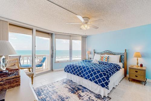 a bedroom with a bed and a view of the ocean at The Sea Goose in Ormond Beach