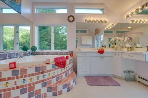 a bathroom with a tub and a sink and windows at Charming Thornton Escape with Sauna and Gazebo! in Thornton