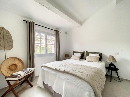 une chambre blanche avec un grand lit et une fenêtre dans l'établissement Mazet*** vue mer, centre et plage à pied, à Sainte-Maxime